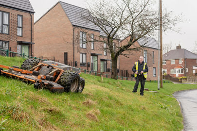 RBH Neighbourhood Environment Team member cutting the grass in Kirkholt with the spider-mower.